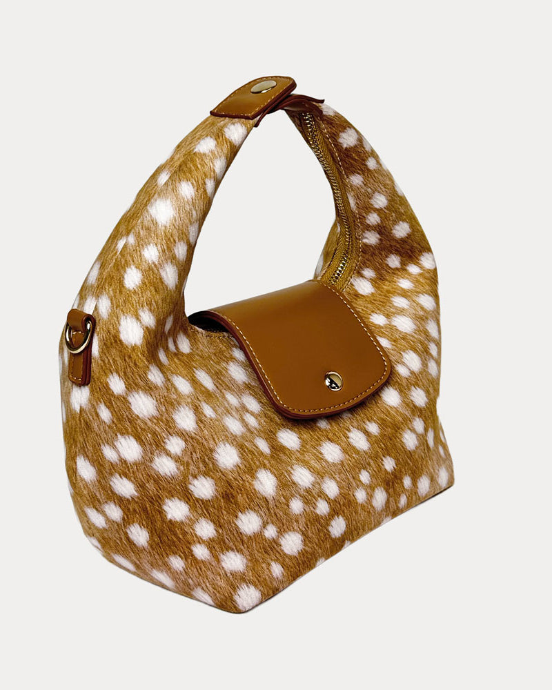 Handbag with deer print and camel leather accents on a light gray background- Side View