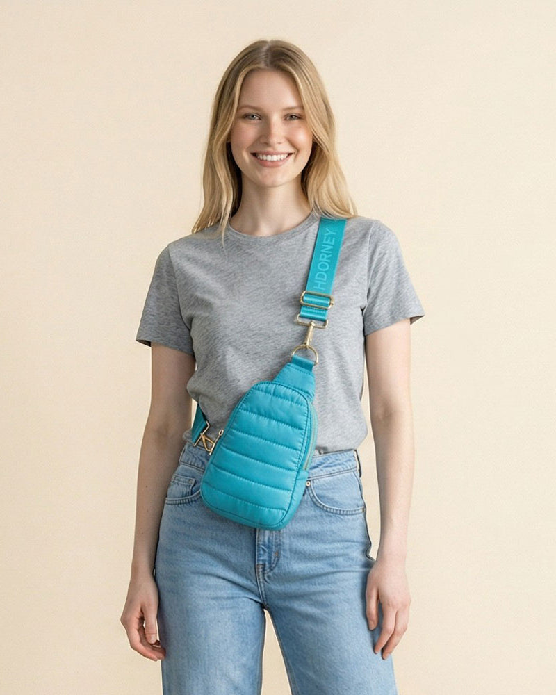 Woman wearing a Turquoise crossbody sling bag against a beige background