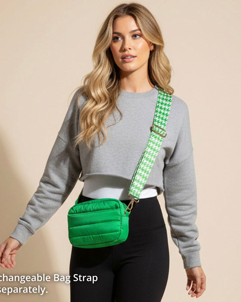 Woman wearing a green puffer bag with a houndstooth strap on a beige background