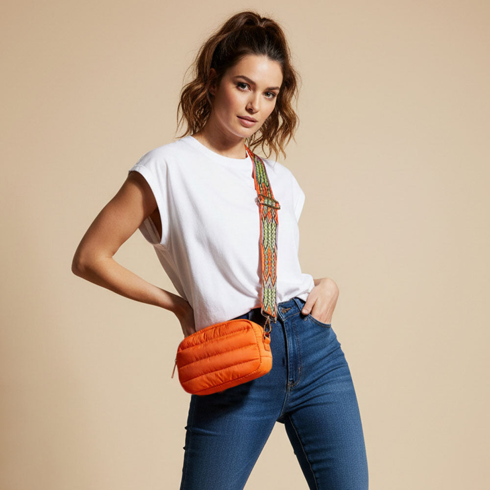 Woman wearing an orange puffer bag with a beige background