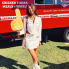 woman posing with #1 foam finger, wearing the yellow & purple striped game day bag strap with the Bailey Clear Game Day Bag