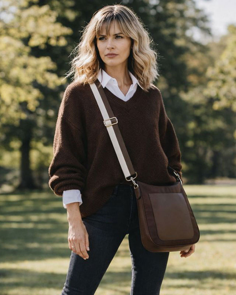 Woman in a brown sweater with a brown bag in a park