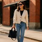 Woman walking down the city street, holding a black tote bag