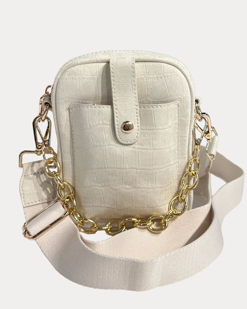 Cream handbag with gold chain strap on a light gray background