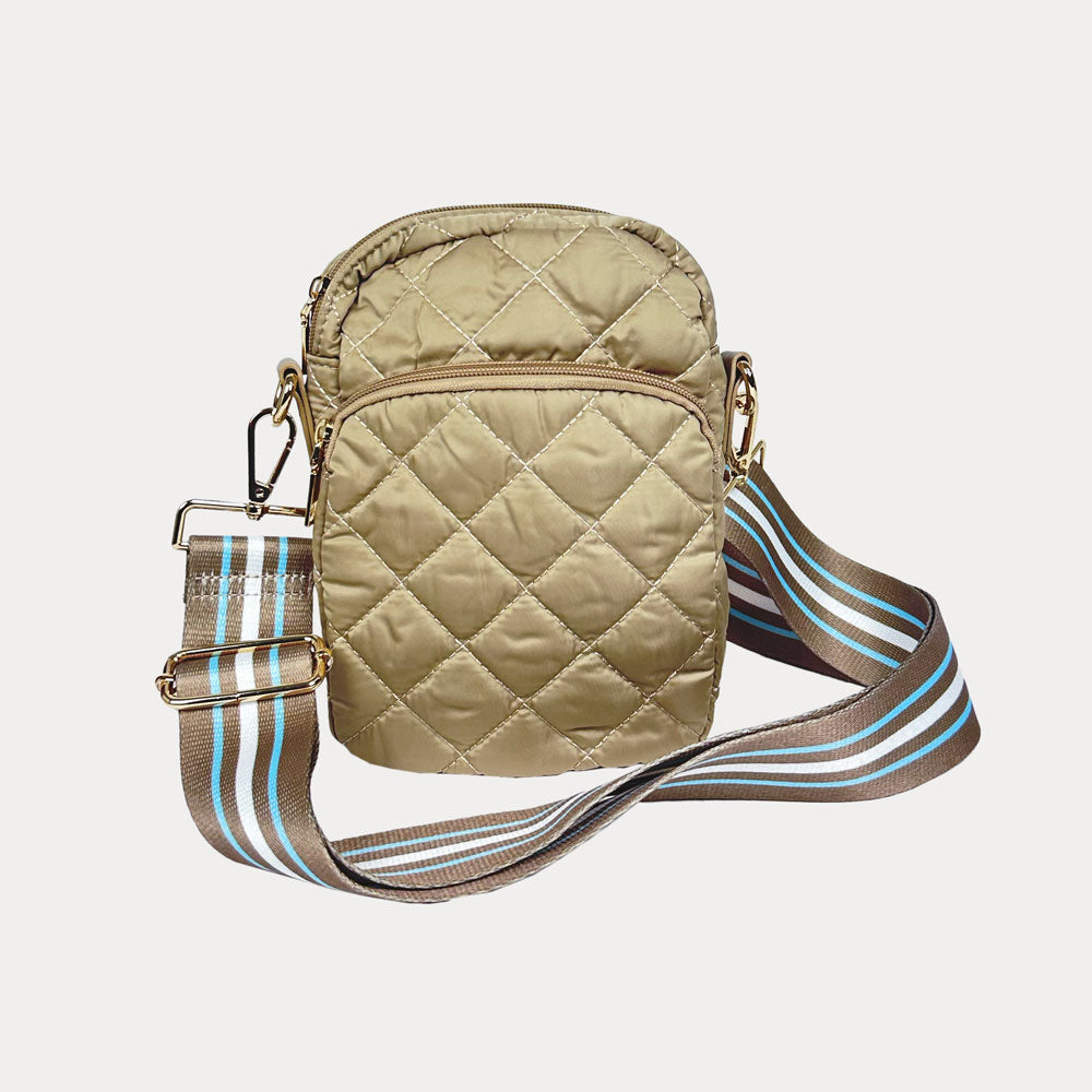 Beige quilted crossbody bag with a striped strap on a light gray background