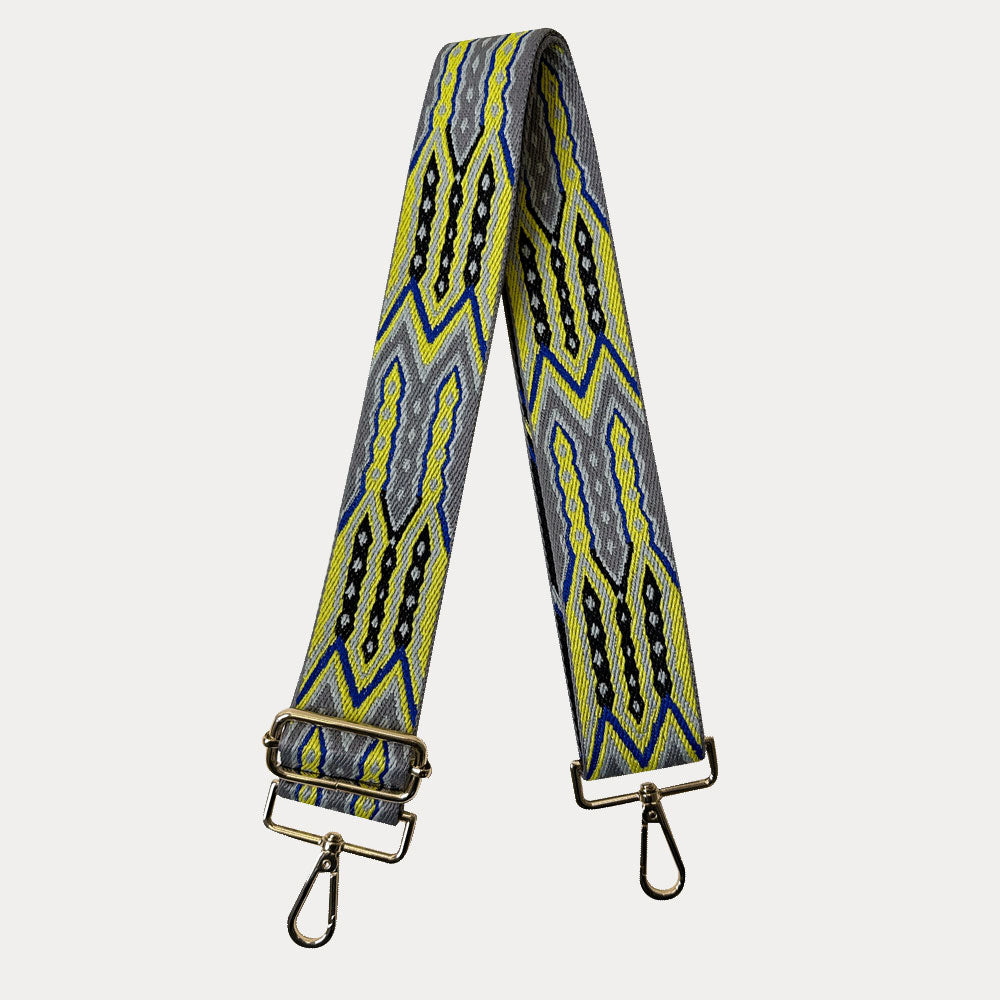 Yellow, Grey, Black patterned strap with silver hardware on a light grey background