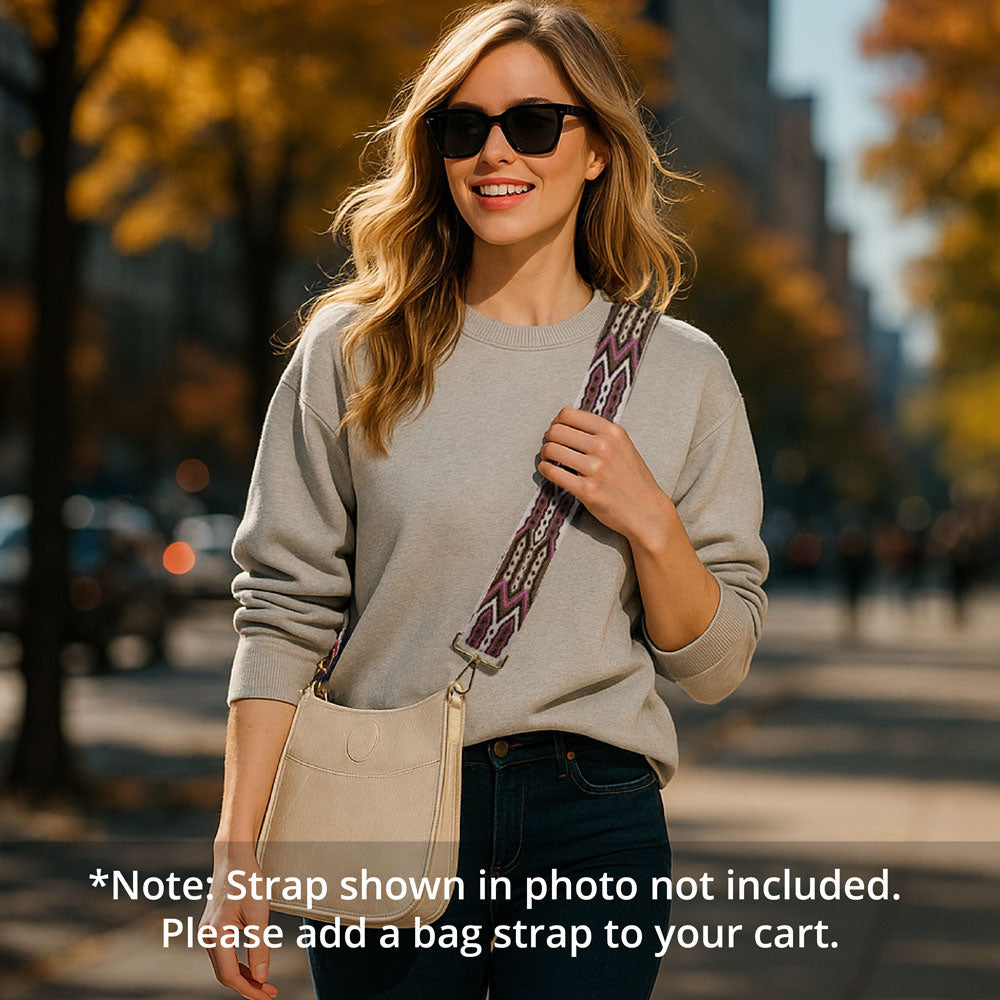 Woman walking in the park, wearing a cream crossbody bag with a patterned embroidered bag strap
