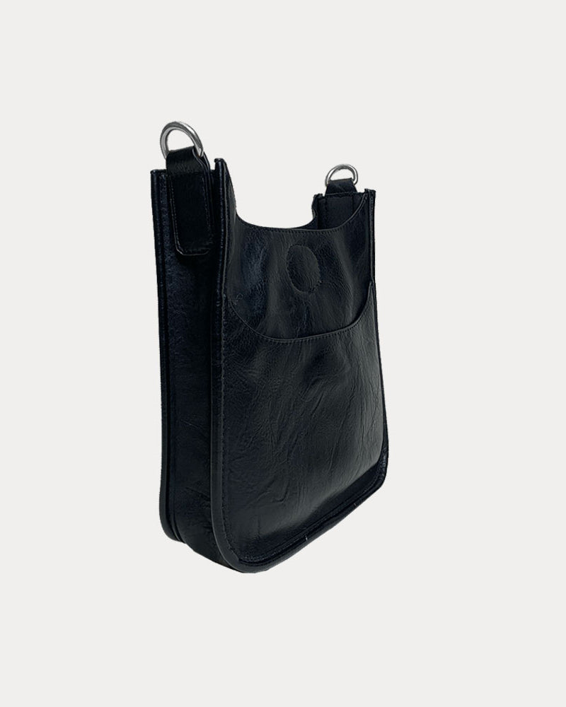 Side view of the Mini Vegan Leather Messenger in Black with Silver Hardware on grey background