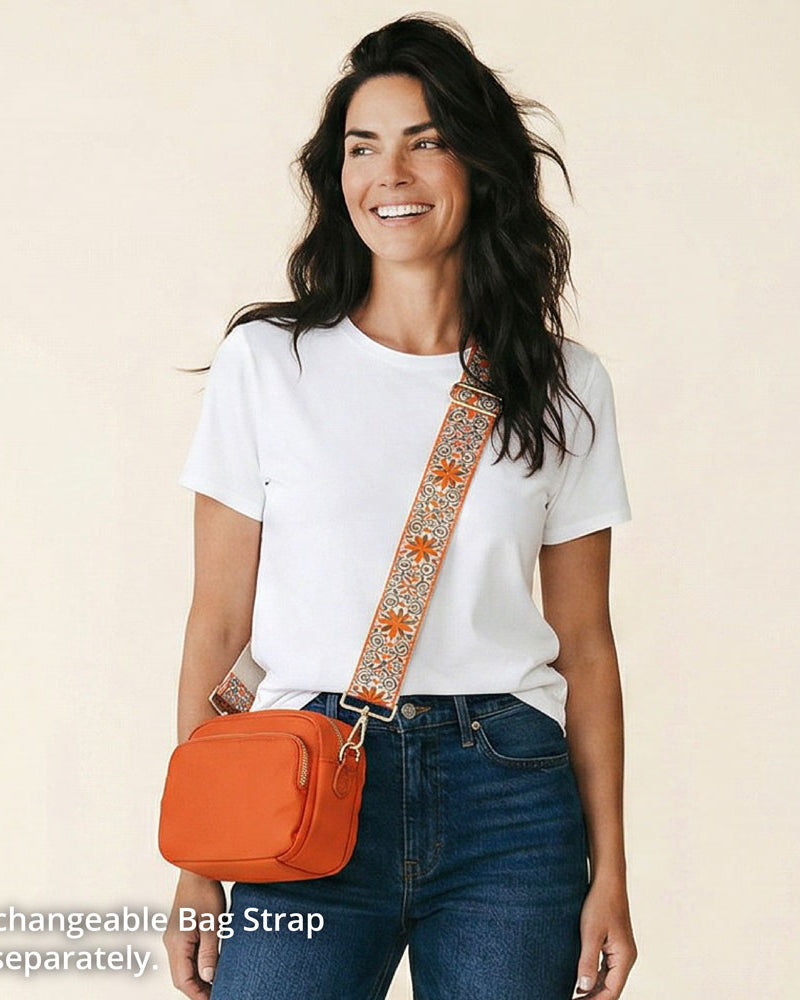 Woman wearing an orange bag with a decorative strap on a beige background