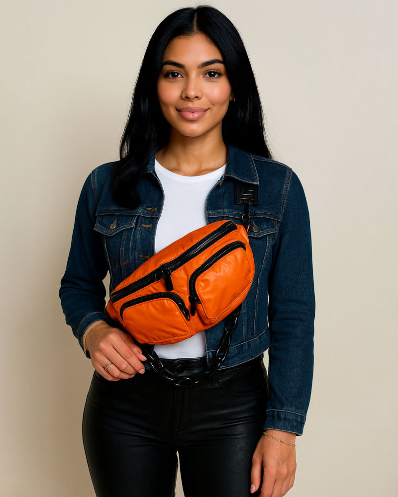 Woman wearing an orange fanny pack against a beige background