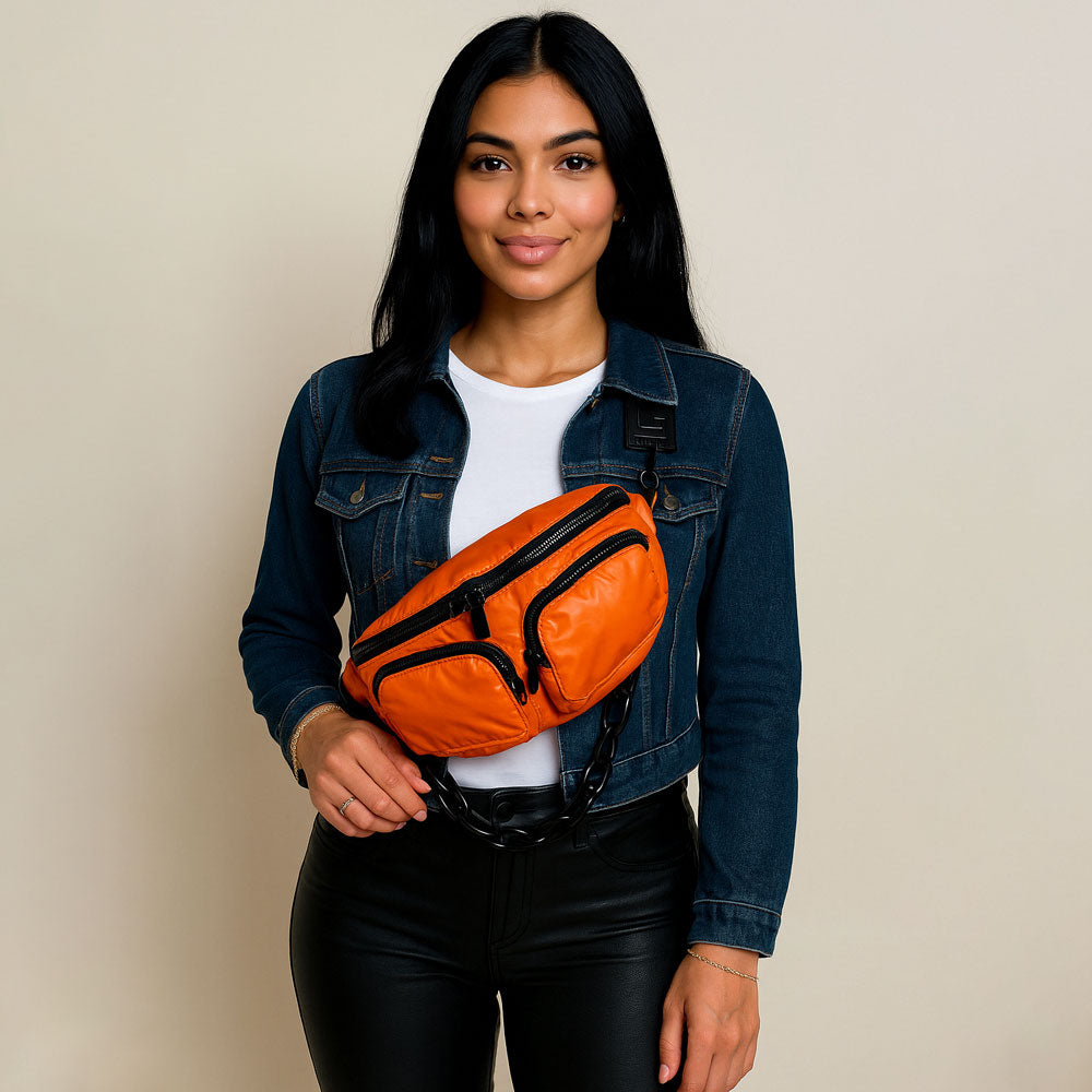 Woman wearing an orange fanny pack against a beige background