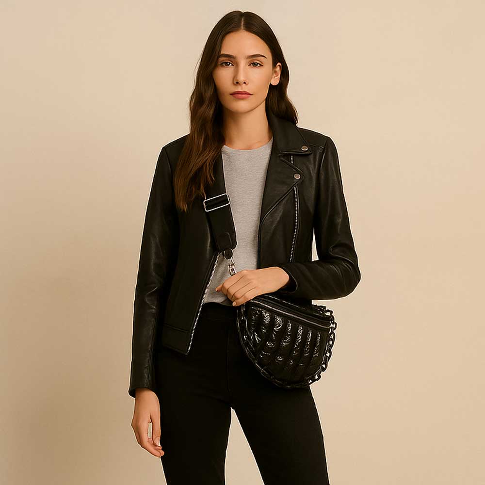 Woman wearing a black leather jacket holding a black handbag against a beige background