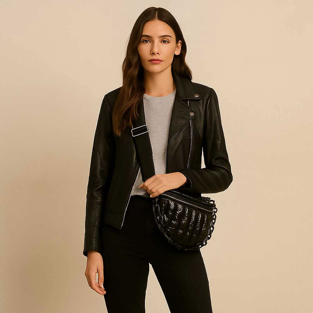 Woman wearing a black sling bag in front of a beige background