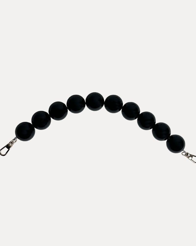 A black colored resin bead bag strap.