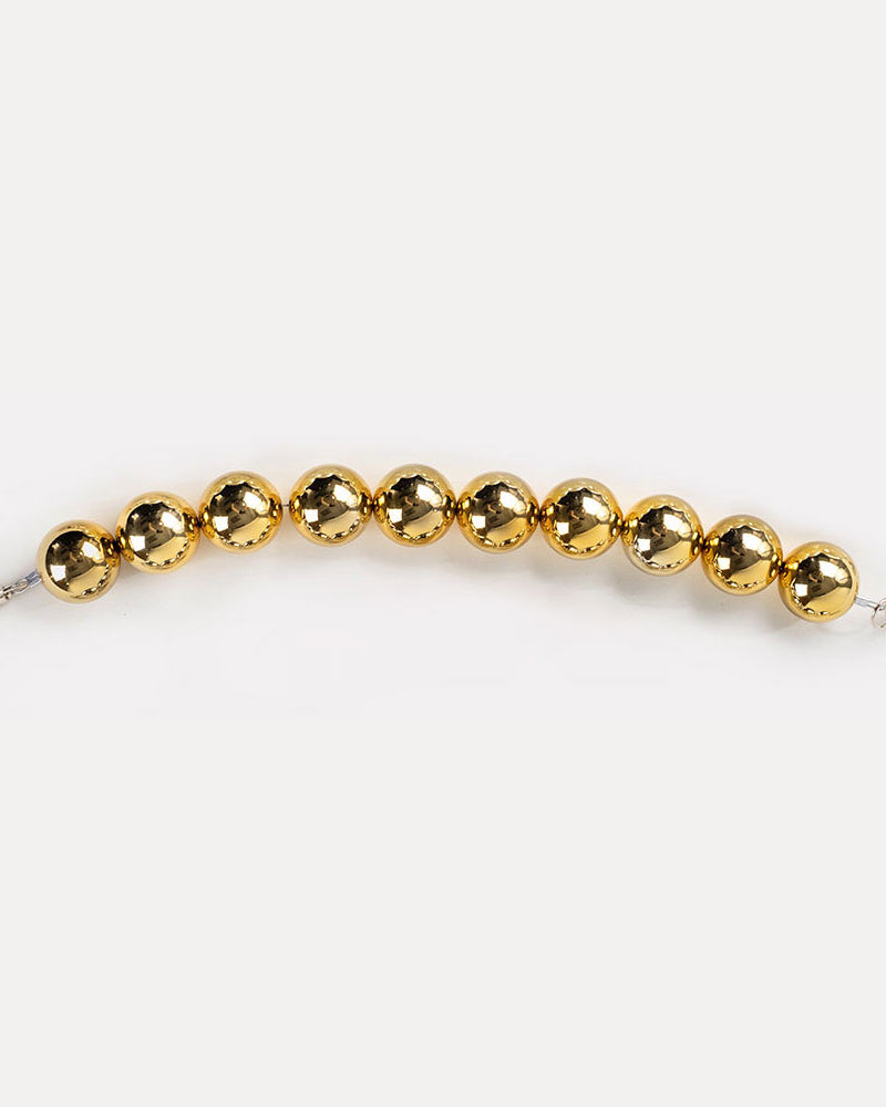 A gold-colored resin bead bag strap.
