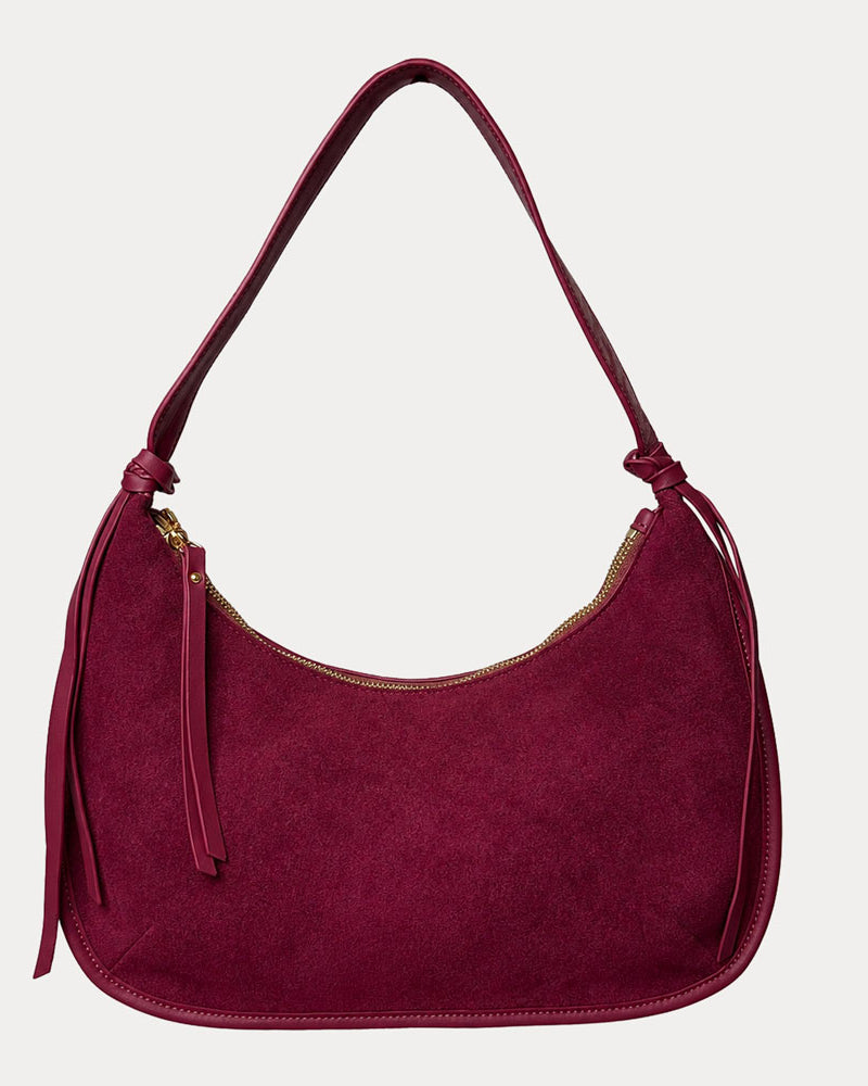 Burgundy vegan suede handbag on a light gray background