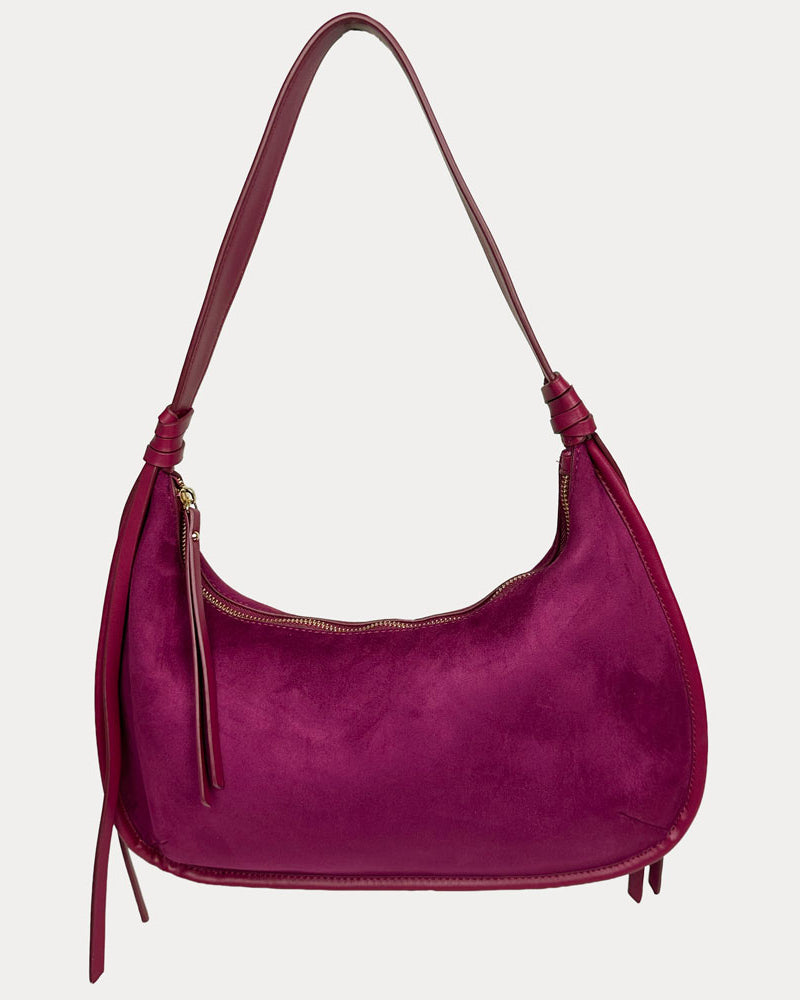 A burgundy vegan suede shoulder bag with a vegan leather details, shown against a light gray background.