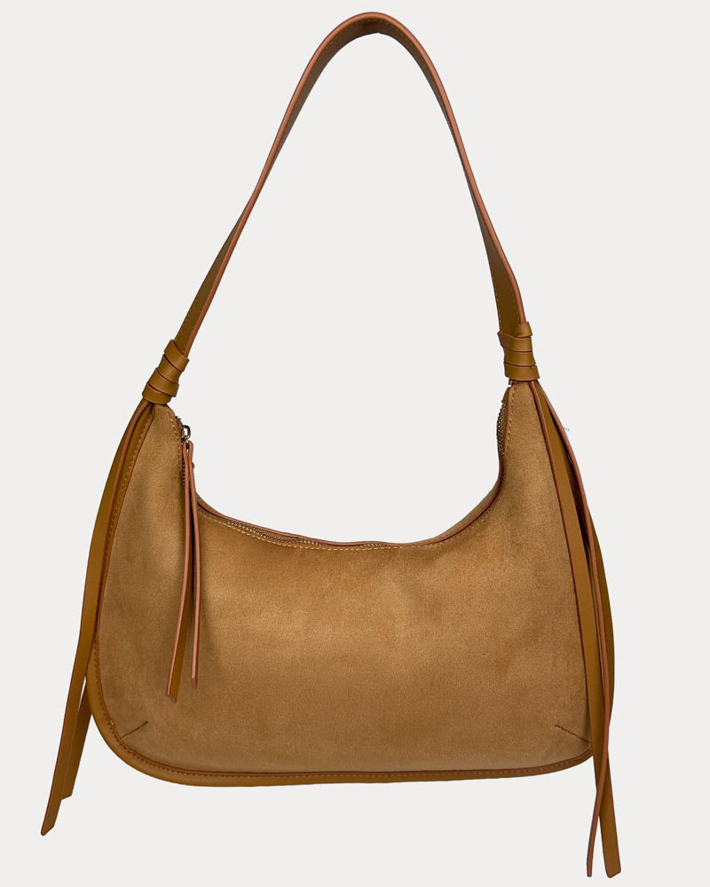 A camel vegan suede shoulder bag with a vegan leather details, shown against a light gray