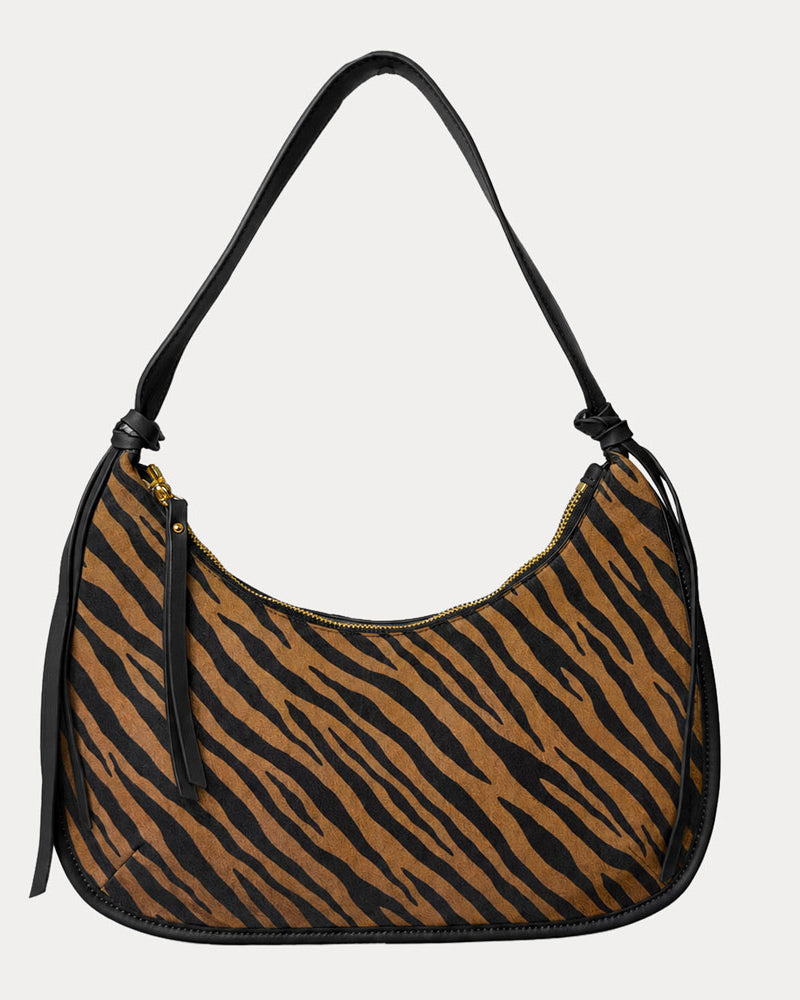 Handbag with zebra pattern vegan suede and black vegan leather details on a beige background