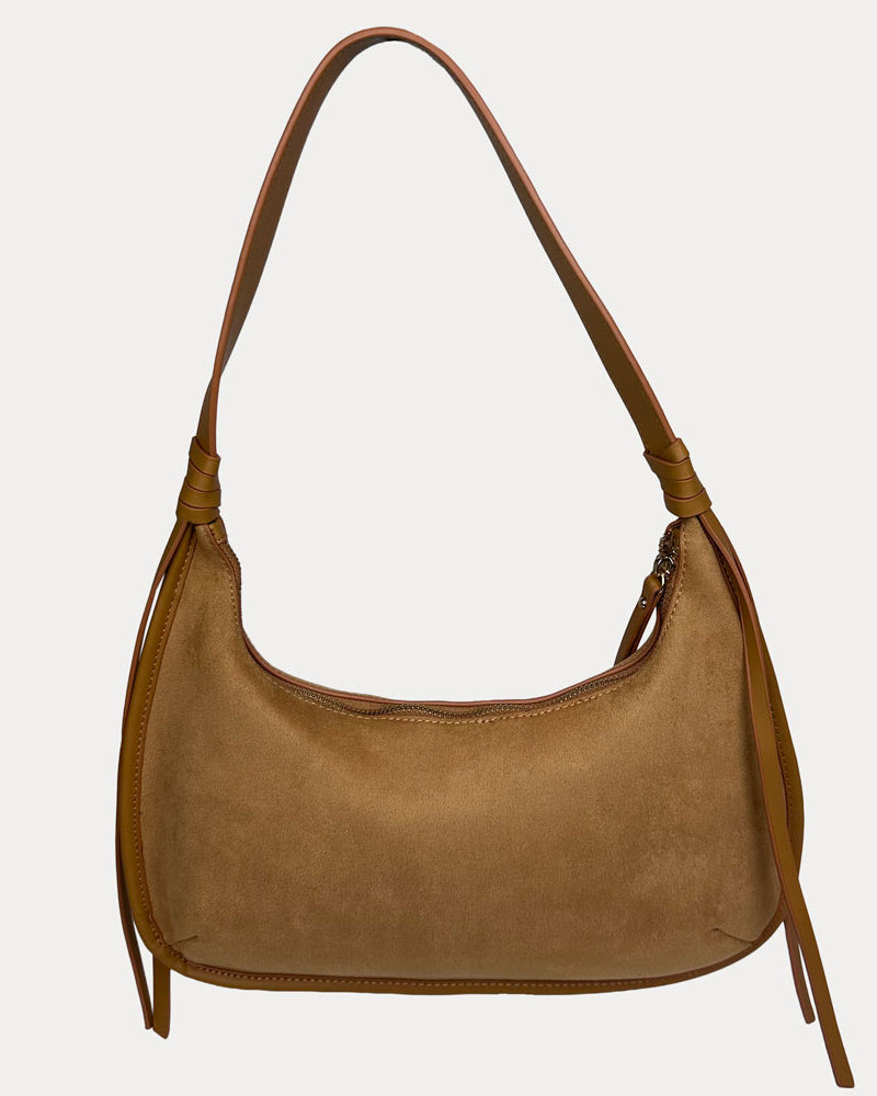 A camel vegan suede shoulder bag with a shoulder strap and long fringe details on the sides, shown against a light gray background.