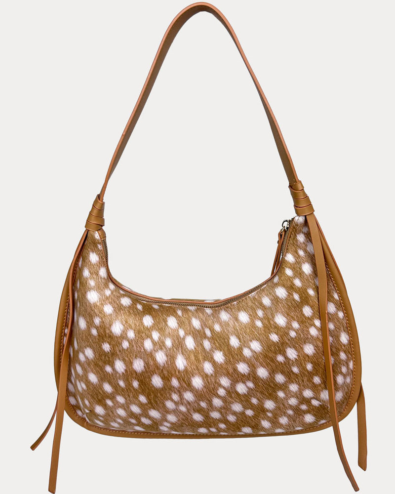 A shoulder bag with a deer animal-print body and camel vegan leather strap, shown against a light gray background.