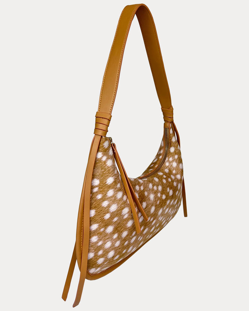 A shoulder bag with a deer animal-print body and matching camel vegan leather strap, shown on a plain light gray background.