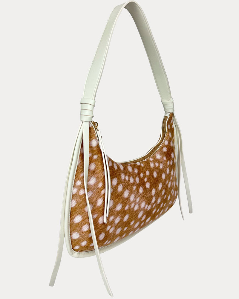 A shoulder bag with a deer animal print body and a solid cream strap, shown against a light gray background.