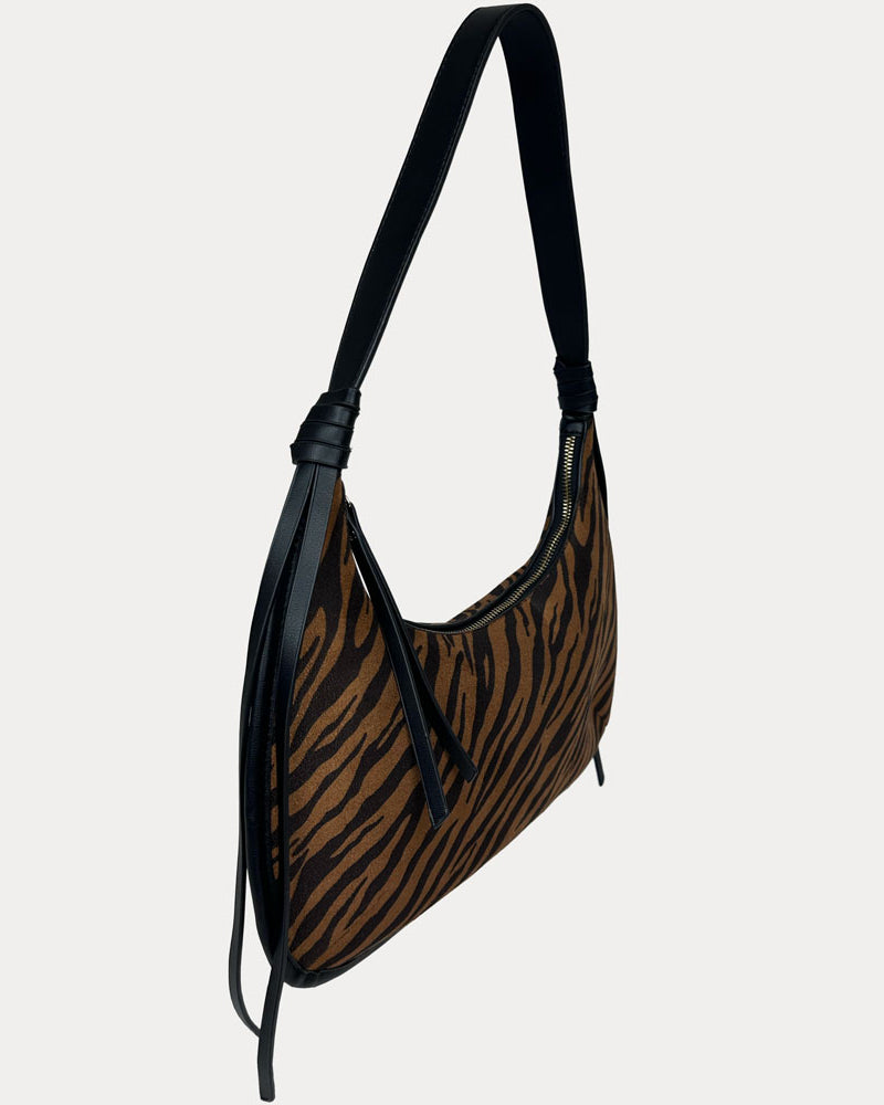 A shoulder bag with a brown and black tiger stripe pattern, featuring black vegan leather trim, shown against a light gray background.