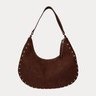 Chocolate vegan suede handbag with studs on a light gray background