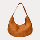 Camel vegan suede handbag with studs on a light gray background