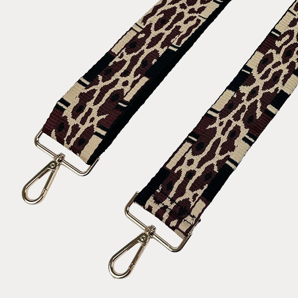 Leopard print bag strap with gold metal clasps on a white background