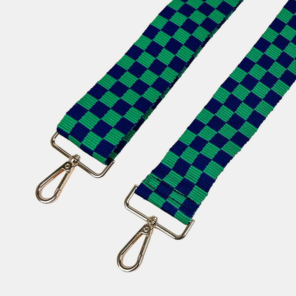 Green and navy checkered bag strap  with gold metal clasp trim on a white background