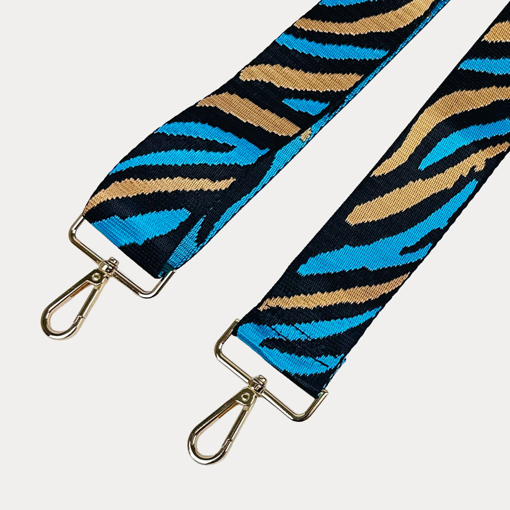 Zebra patterned strap with gold metal clasps on a white background