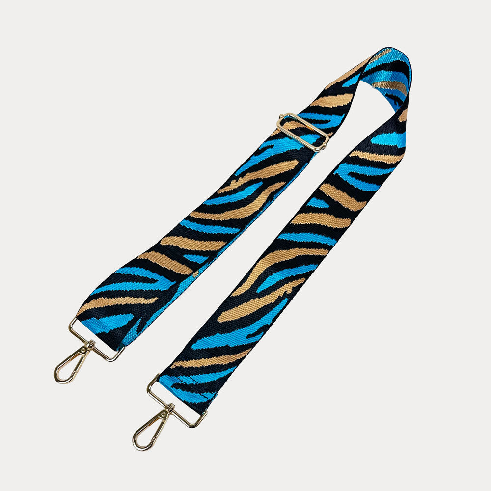 Zebra patterned strap with gold hardware on a white background