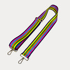 Bright multi colored striped bag strap with gold hardware on a light gray background