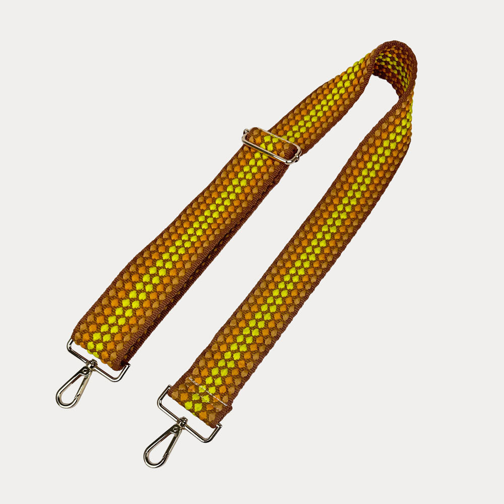 Yellow and brown patterned bag strap on a light gray background