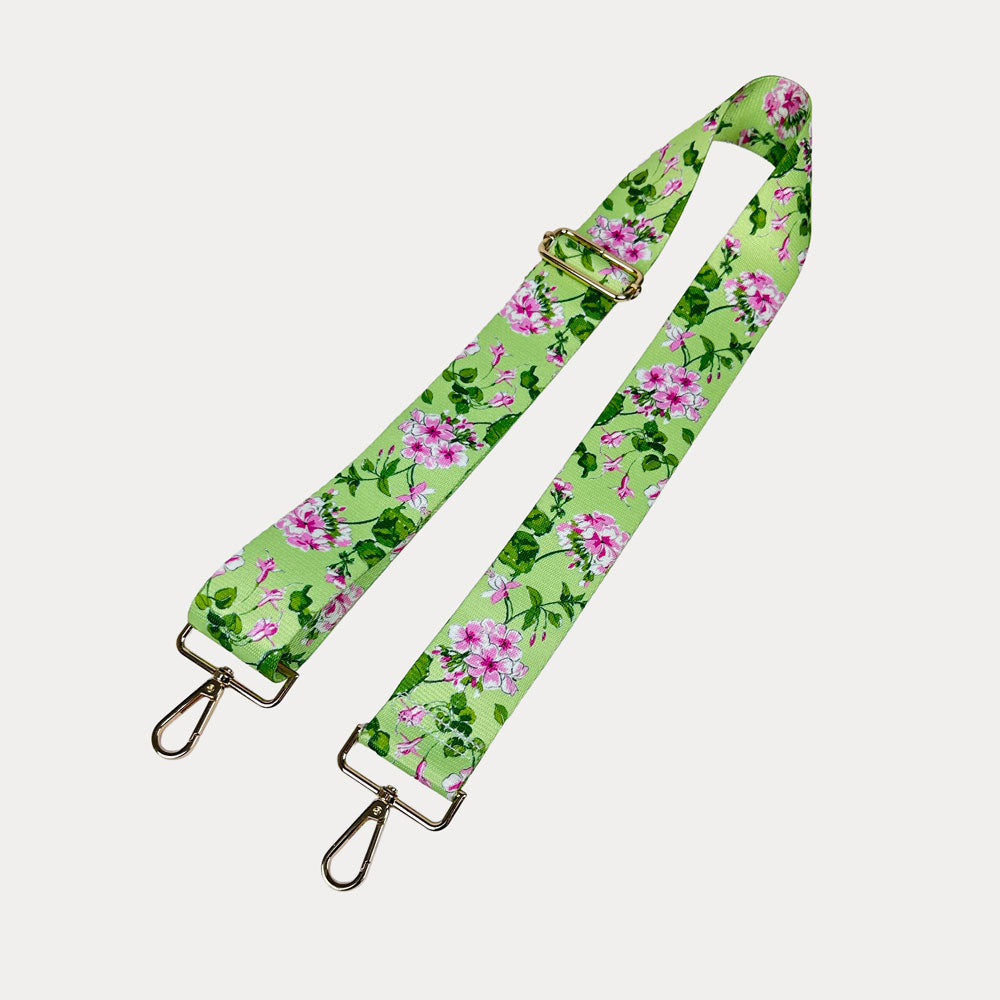 Lime ground floral patterned strap with gold hardware on a light gray background