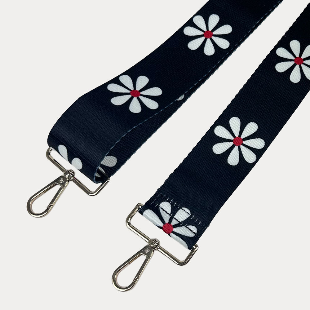 Black ground with White Flower Print bag strap with gold metal clasps on light grey background