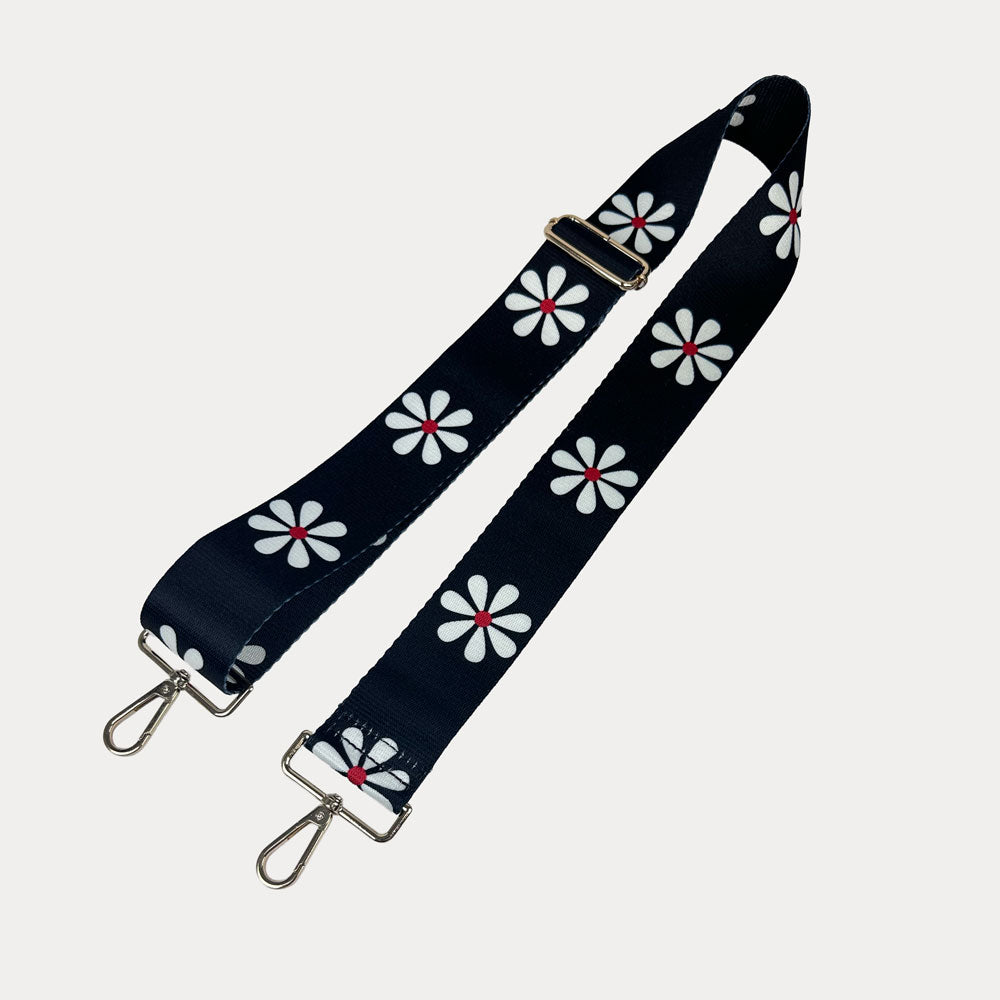 Black ground with White Flower Print bag strap with gold metal clasps on light grey background
