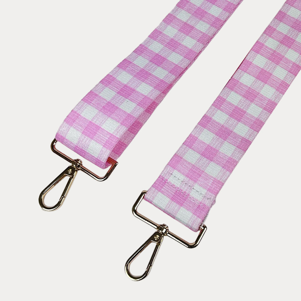 Pink and white checkered strap with gold metal clasps on a light gray background