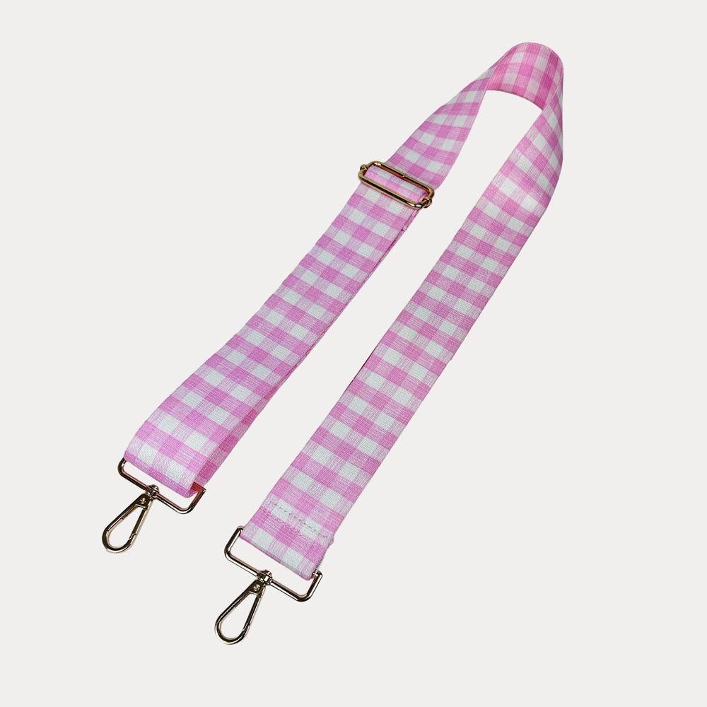 Pink and white checkered strap with gold metal clasps on a light gray background