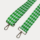 Green and white houndstooth patterned strap with gold metal clasps on a light gray background