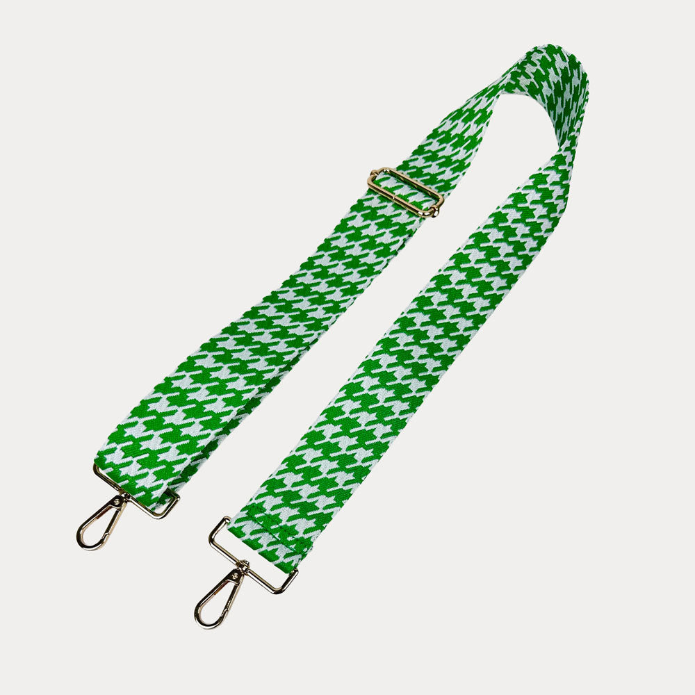 Green and white houndstooth patterned strap with gold metal clasps on a light gray background