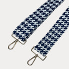 Navy and white houndstooth patterned strap with gold metal clasps on a light gray background
