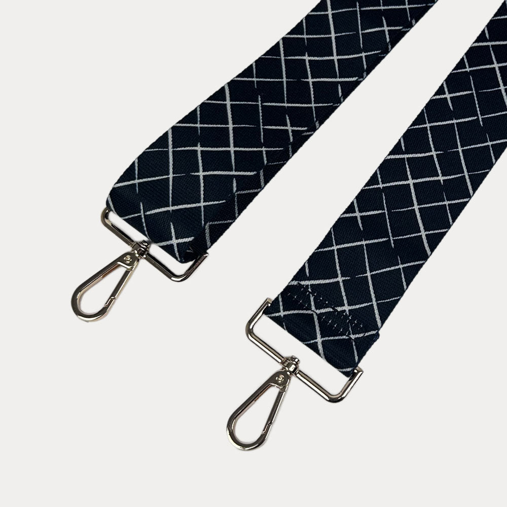 Black and white patterned strap with gold hardware on a white background