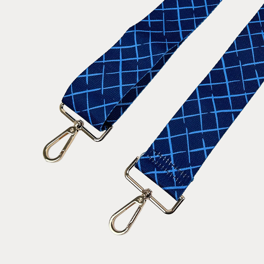 Navy and blue patterned strap with gold hardware on a white background