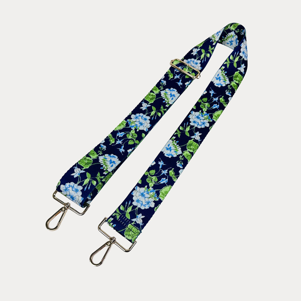 Navy ground floral patterned strap with gold hardware on a light gray background