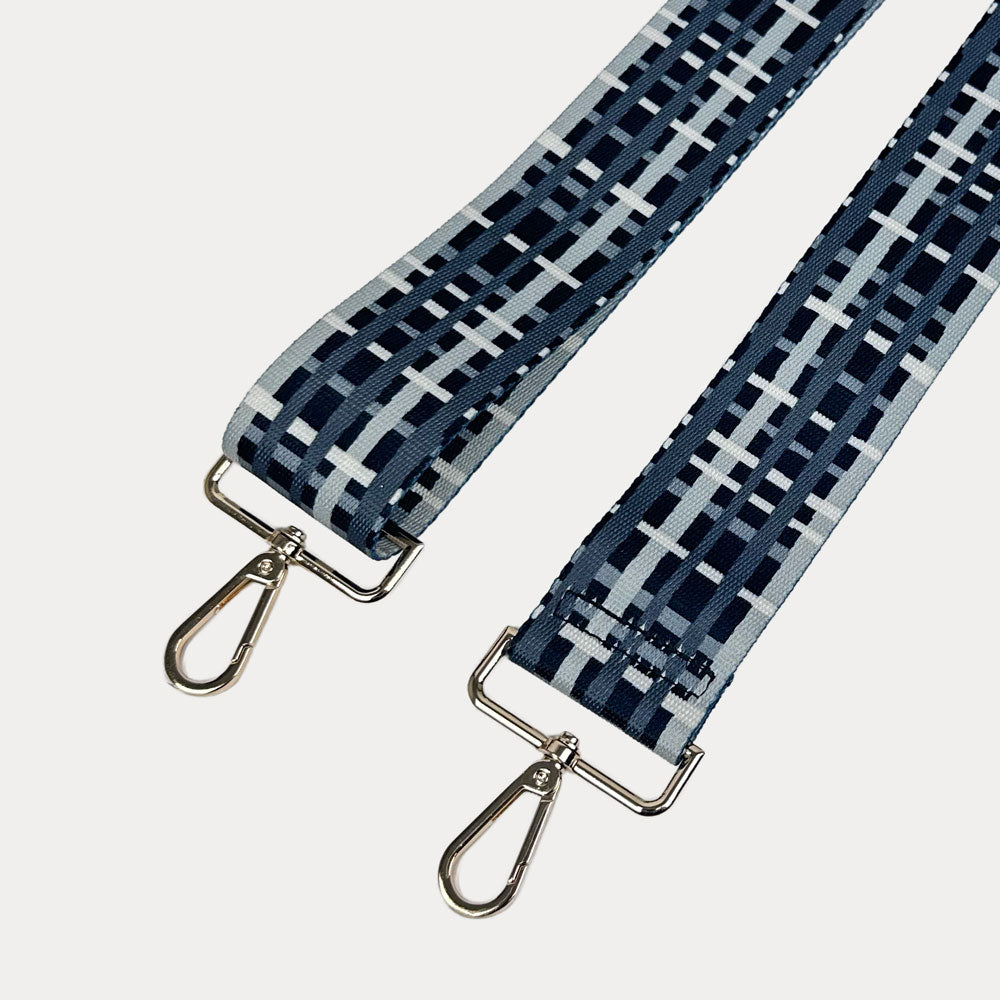 Black and grey plaid strap with gold metal hardware on a white background
