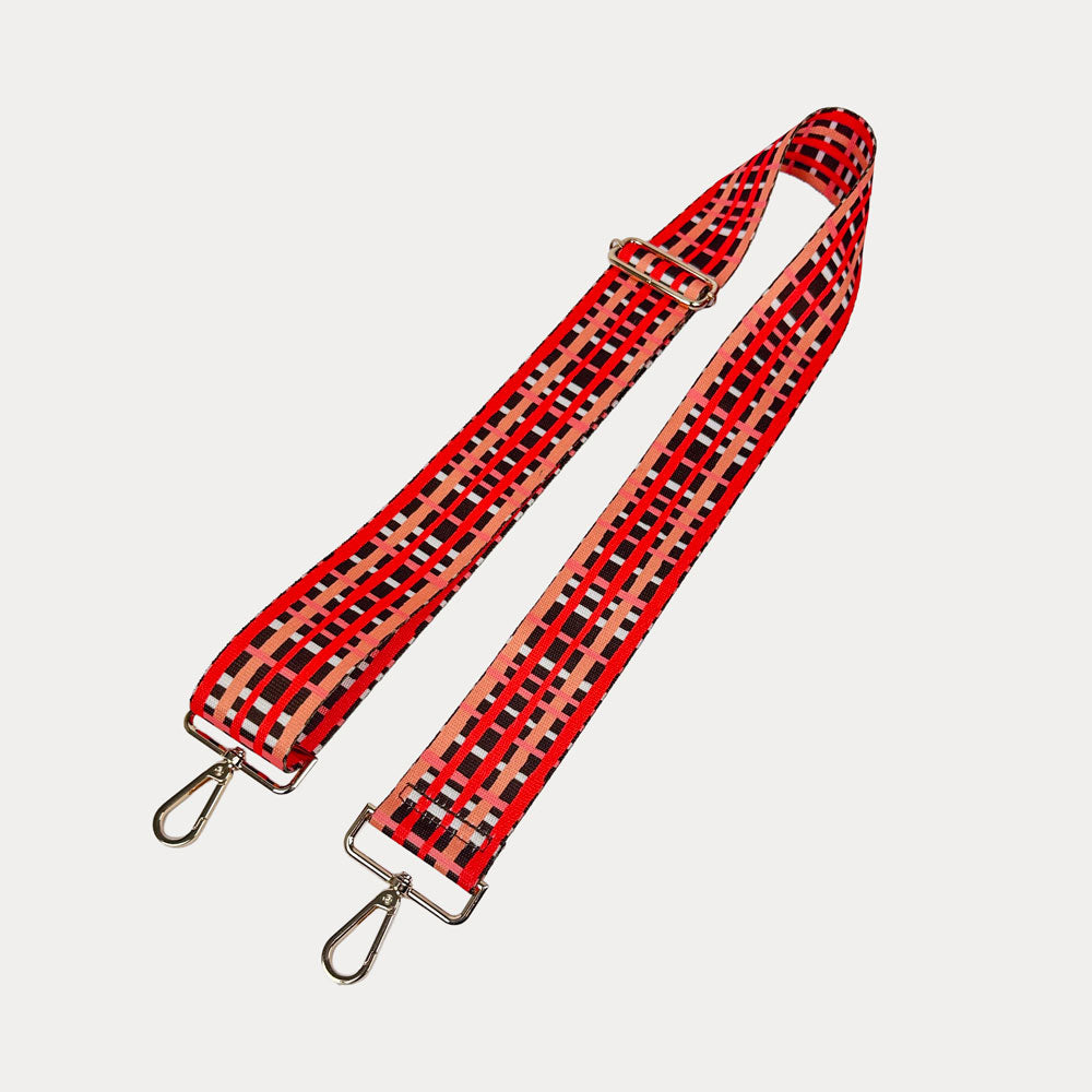 Brown, red and peach plaid strap with gold metal hardware on a white background