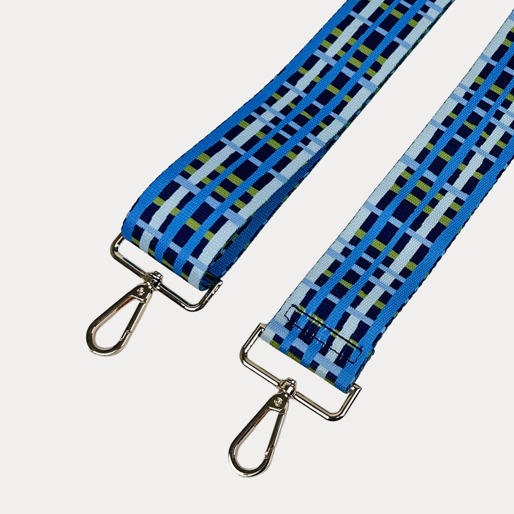 Navy, blue and green plaid strap with gold metal hardware on a white background